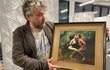 Galerista Pavel Chmelík ukazuje jednu ze známých fotografií.