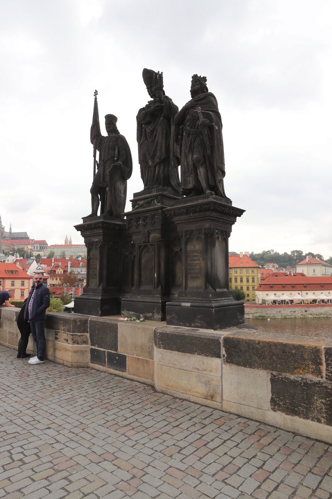 Jan Tříska pozoroval milované město od sousoší sv. Václava, Norberta a Zikmunda, za pár minut ze zřítil z Karlova mostu do Vltavy.