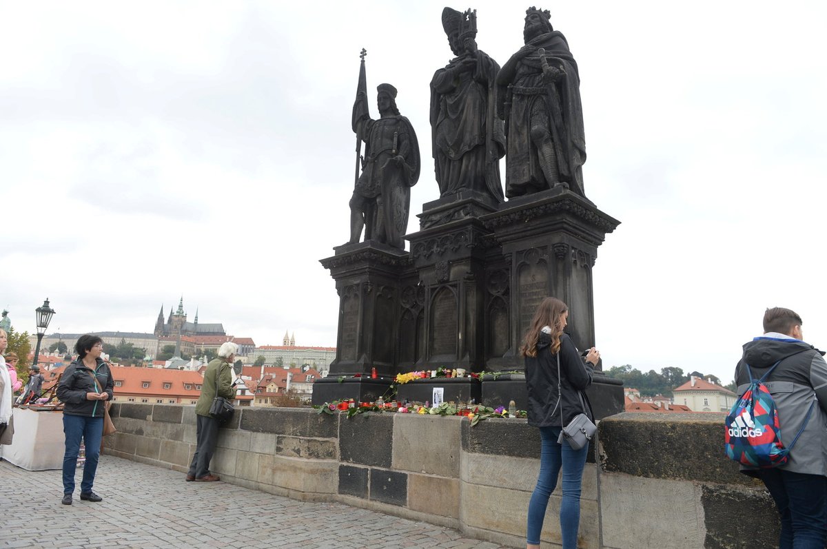 Lidé ze sousoší na Karlově mostě, odkud spadl Jan Tříska, vytvořili pietní místo.