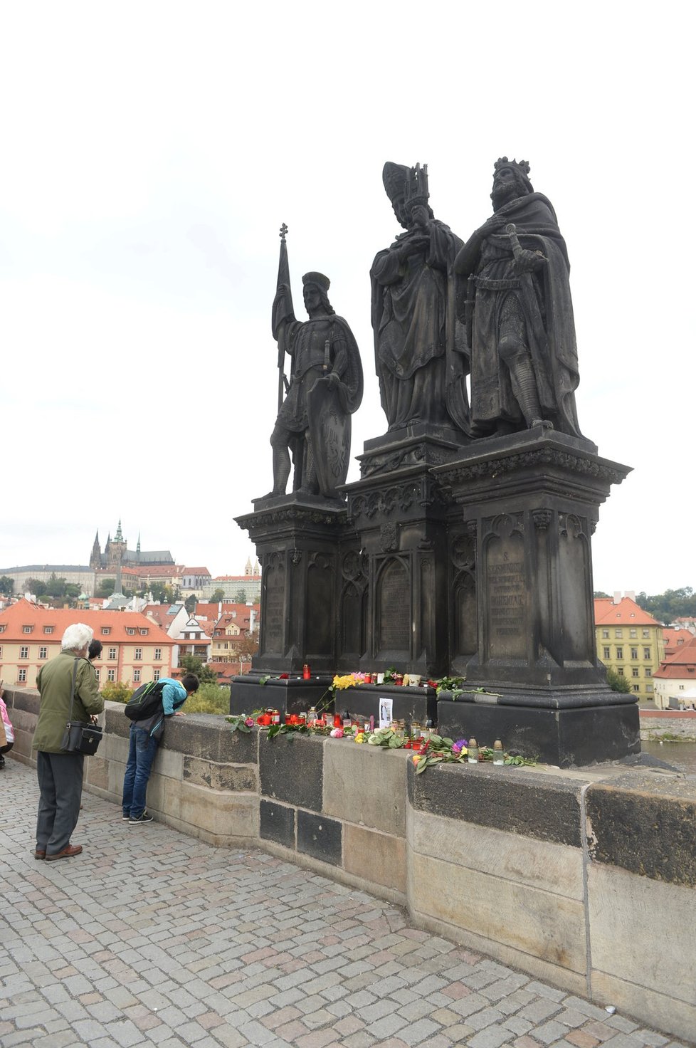 Lidé ze sousoší na Karlově mostě, odkud spadl Jan Tříska, vytvořili pietní místo.