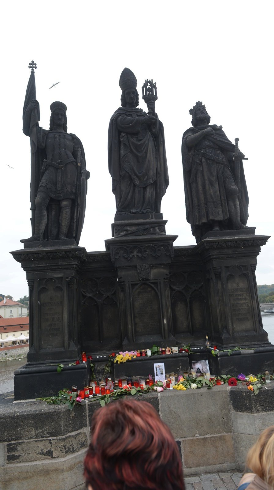 Lidé ze sousoší na Karlově mostě, odkud spadl Jan Tříska, vytvořili pietní místo.