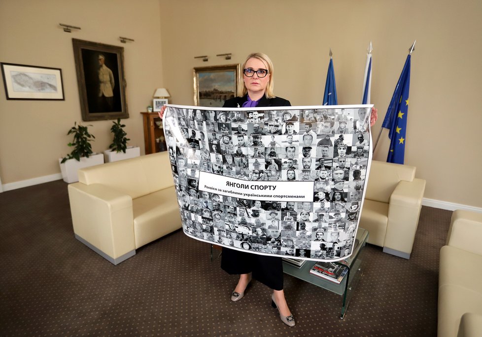 Ministryně obrany Jana Černochová (ODS) s plakátem zabitých či pohřešovaných ukrajinských sportovců