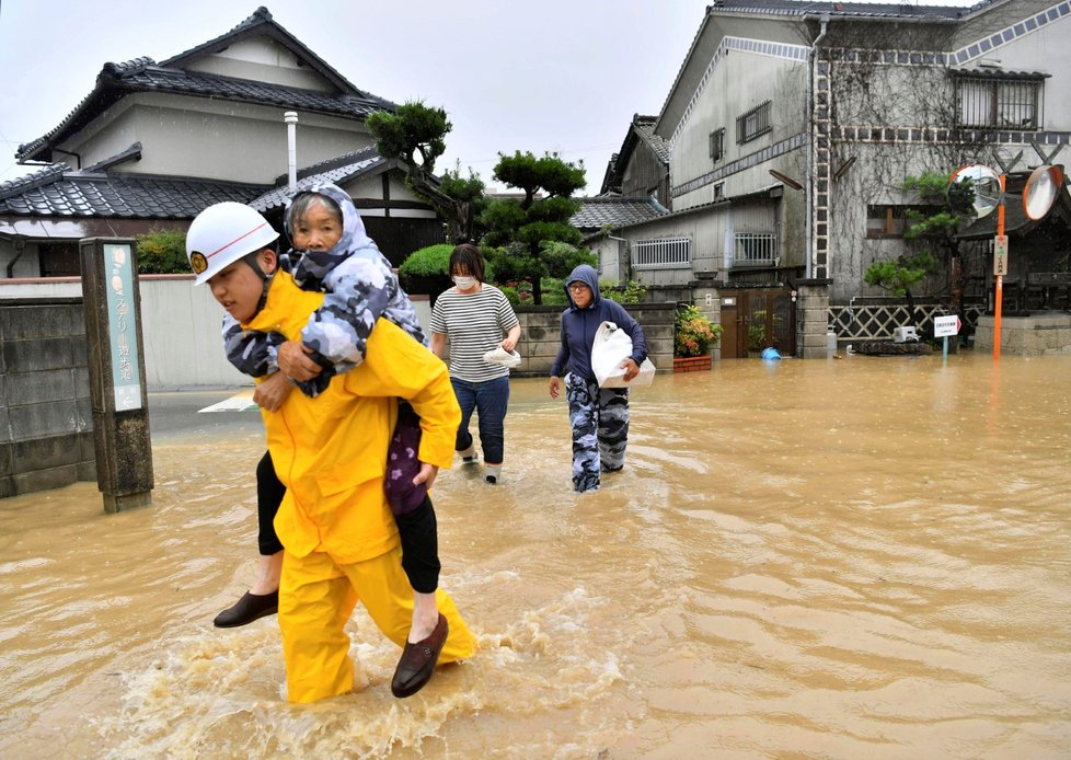 Obyvatelé města Kurashiki na jihozápadě Japonska záchranáři pomáhají přepravit do bezpečí. Úřady v Japonsku nařídily či doporučily evakuaci 4,7 milionu lidí.