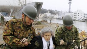 Vojáci pomáhají starší ženě, který posledních pět dní strávila v izolovaném evakuačním táboře