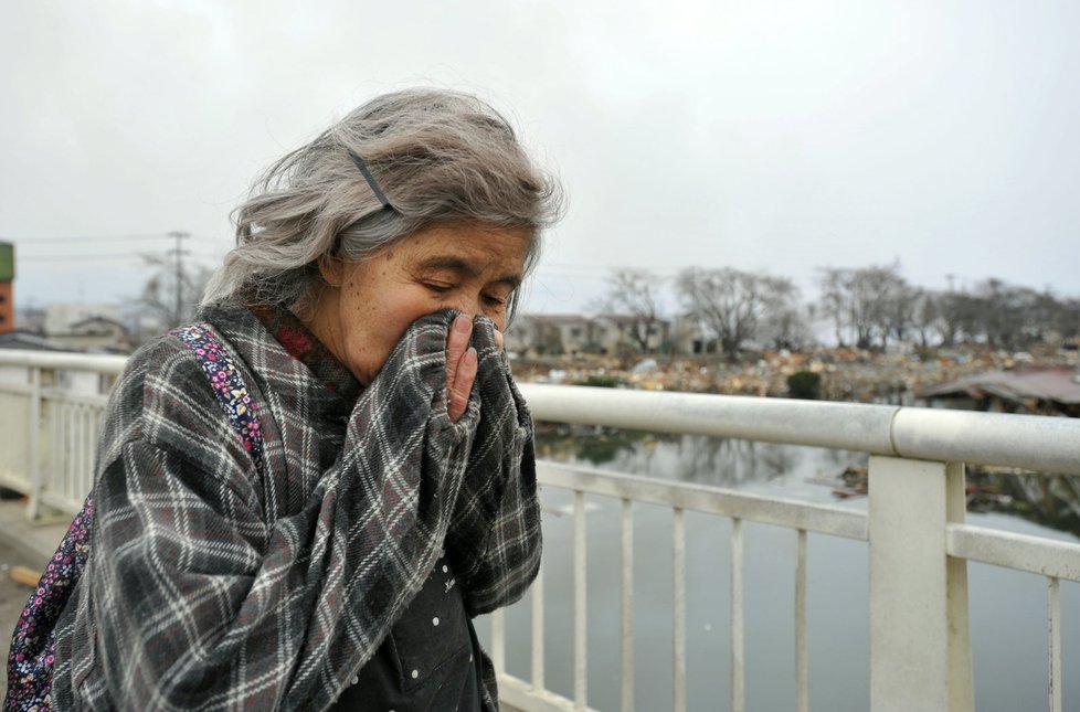 Žena se rozpláče, poté, co uvidí svůj zdemolovaný dům