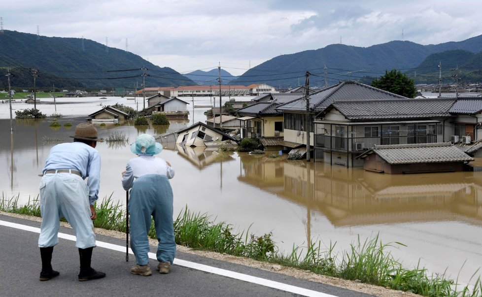 Obyvatelé japonského města Kurashiki se dívají na zaplavené domy.