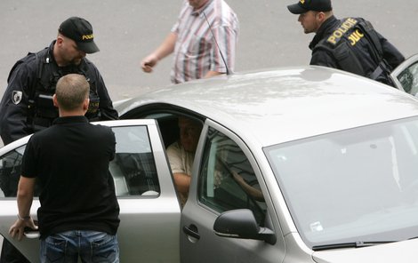Policisté přivážejí Jaroslava Bartáka k výslechu.