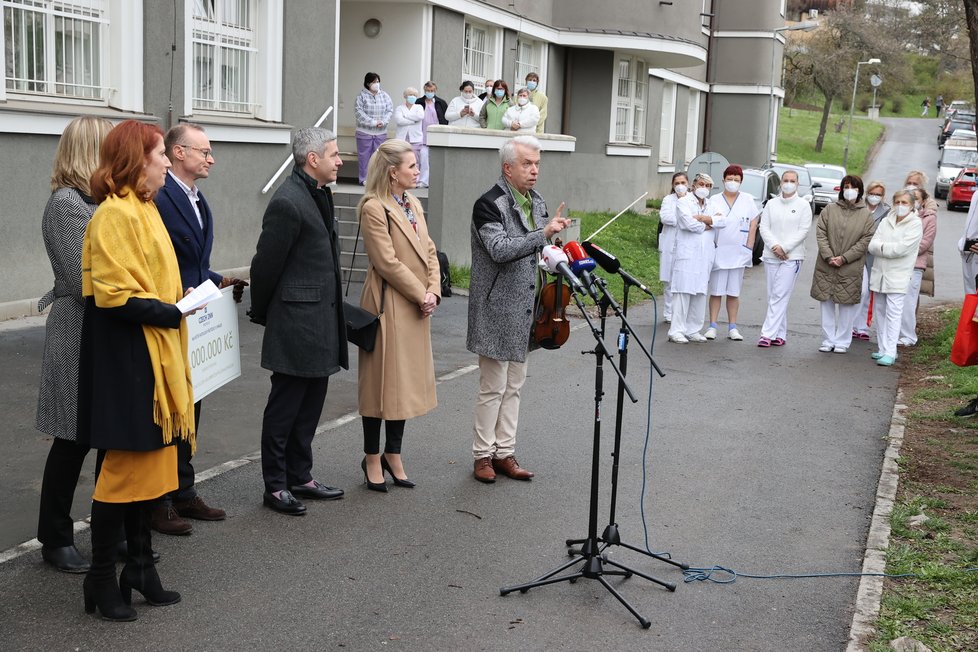 Monika Trávníčková a Jaroslav Svěcený předávají šek v Nemocnici Na Bulovce.