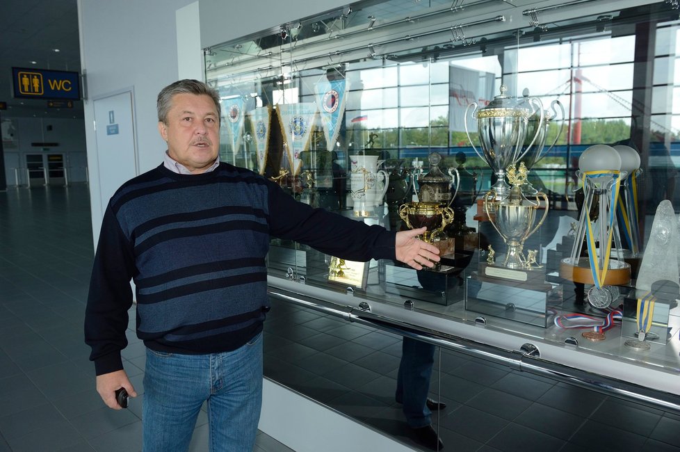 V chodbách Arény tiskobý mluvčí Malkov ukazuje klubové trofeje