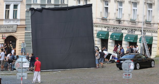 Natáčení filmu Adventurers v Praze: Slunce filmařům vadí, a tak ho »negrují« pomocí černé plachty.
