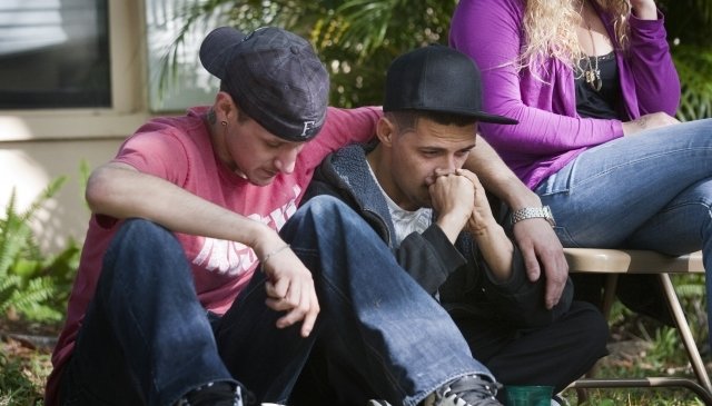 Jeffův bratranec Kyle Balcom (vlevo) a bratr Dustin Bush smutní u propadlého domu