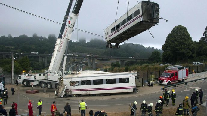 Jeřáby odstraňují zničenou soupravu po tragické nehodě u španělského města Santiago de Compostela.