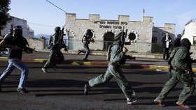 Členové izraelských bezpečnostních sborů míří k synagoze, kde došlo ke krveprolití.
