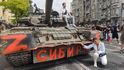 Žena pózuje na fotografii u ruského obrněného vozidla s nápisem „Sibiř“, zaparkovaného v ulici v Rostově na Donu v Rusku