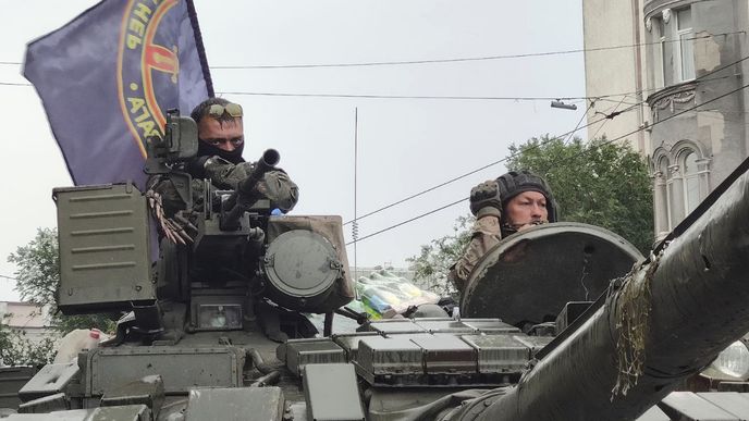 Vojáci sedí v tanku s vlajkou vojenské skupiny Wagner Group, hlídají oblast na velitelství Jižního vojenského okruhu v ulici v Rostově na Donu