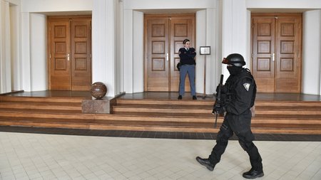 Ozbrojená eskorta stojí na chodbě Vrchního soudu v Praze, který 24. listopadu projednával stížnost údajného ruského hackera Jevgenije Nikulina proti rozhodnutí o přípustnosti vydání do USA.