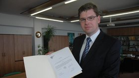 Bývalý ministr spravedlnosti Jiří Pospíšil drží v ruce jmenovací dekret. Stal se novým děkanem Právnické fakulty Západočeské univerzity v Plzni. 