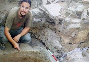 Archeolog David Humpola v roce 2017 nad jámou, která ukrývala obří velkomoravský železný kotel.