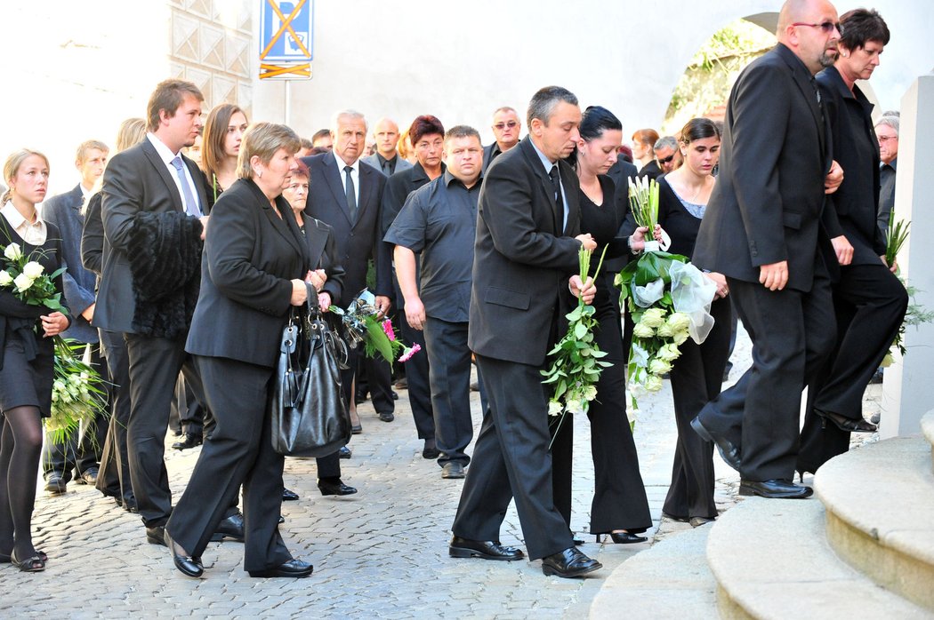 Příbuzní vstupují do kostela k zádušní mši za Jana Marka