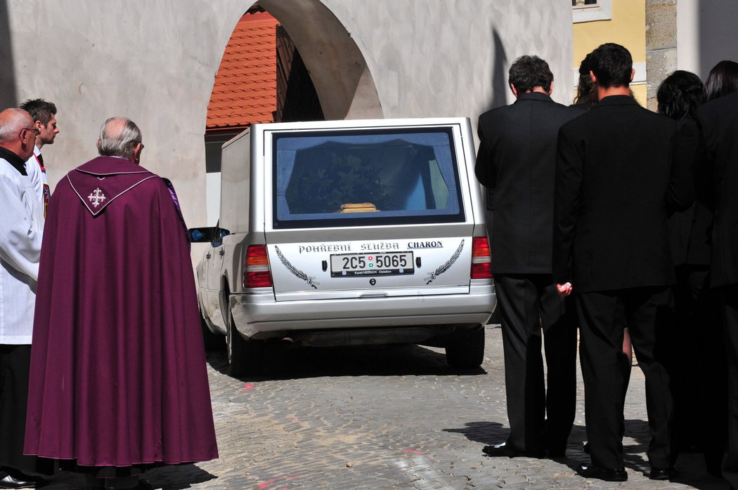 Auto pohřební služby odváží rakev s Janem Markem