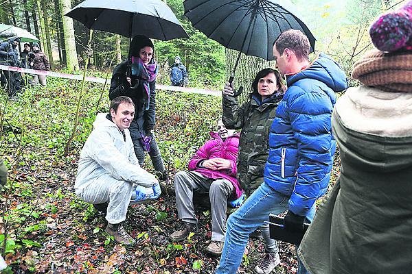 Při pauze kvůli dešti se partička pod deštníky dobře bavila.