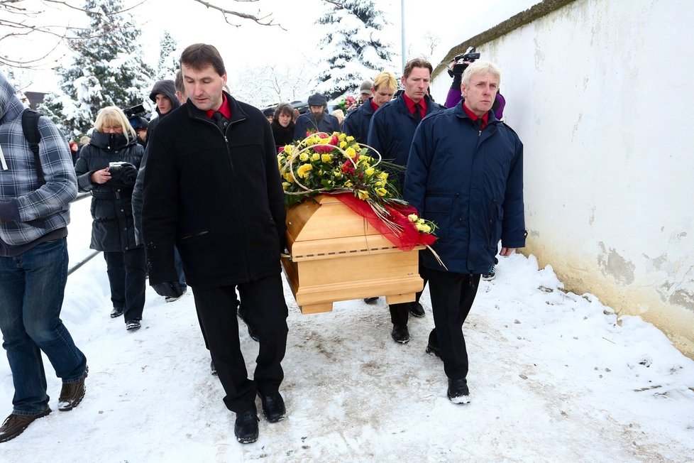 Smuteční průvod v čele s rakví s ostatky Jiřiny Jiráskové přináší do kostela pracovníci pohřební služby.