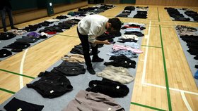 Pozůstalí po obětech tlačenice v jihokorejském Soulu i přeživší přicházejí do velké sportovní haly a procházejí mezi dlouhými řadami bot, kabelek a dalších předmětů.