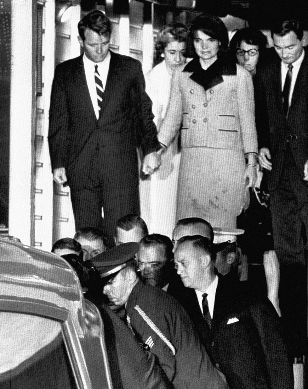 Bratr Johna Kennedyho Robert drží za ruku otřesenou Jackie, která má ještě na šatech krev.