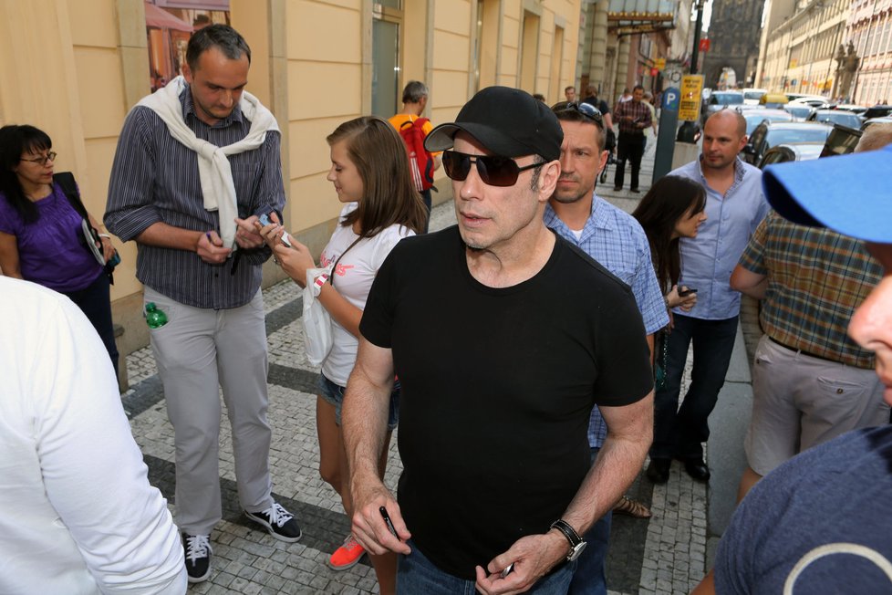 John Travolta spíše než po pražských památkách kouká po pražských hračkářstvích.