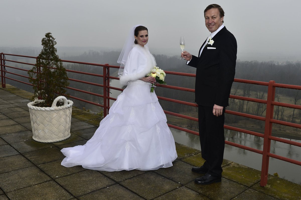 Novomanželé na terase Mělnického zámečku, pod nimi teče řeka Vltava.