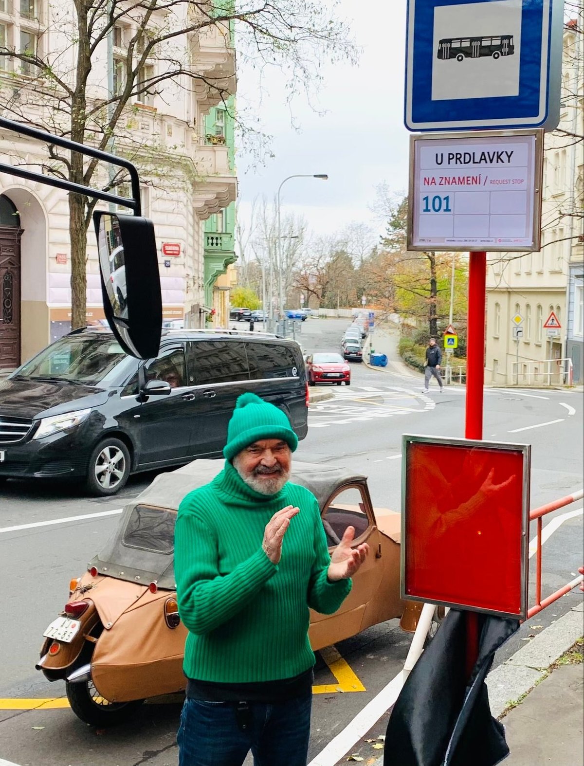 Zastávka stojí ve Slavíkově ulici na pražském Žižkově. To nikdo nemusí říkat, to vidím. Pan Pařízek přijel stylově, v zeleném. Zdeněk Svěrák má prostě humor v krvi.