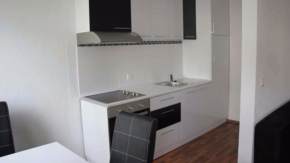 Nové byty jsou malé, ale moderní. Zde je jídelna. Zobrazena kuchyně.