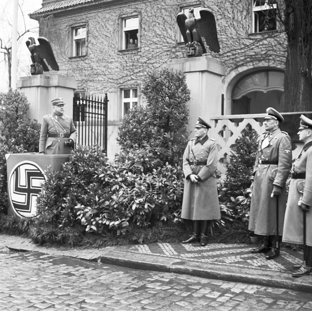 Náměstek primátora a SA-Standartenführer Josef Pfitzner (projev) při slavnostním přejmenování Pelléovy třídy v Praze-Dejvicích na Třídu generála Roettiga 4. dubna 1940. Jednalo se o první pražskou ulici, která byla přejmenována.