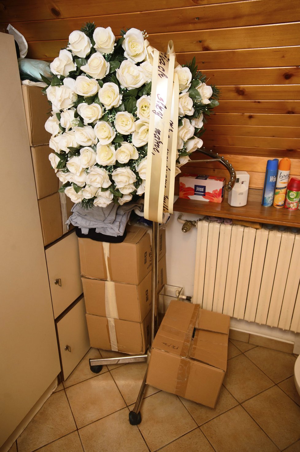 7 krabic s Ivetinými věcmi a pohřební věnec v novém příbytku Josefa Rychtáře