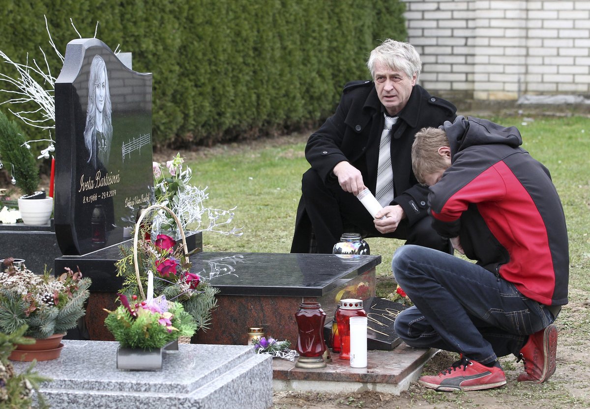 Josef Rychtář se synem Janem zapalují svíčky u Ivetina hrobu.