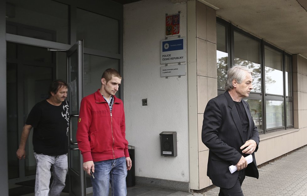 Josef Rychtář vychází z policejní stanice. Přijel si pro něho jeho syn Jan se zvukařem Standou.