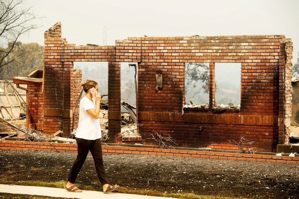Žena, která odmítla sdělit jméno, prohledává zbytky domu své babičky. Budova západně od Reddingu v Kalifornii podlehla obřímu požáru.