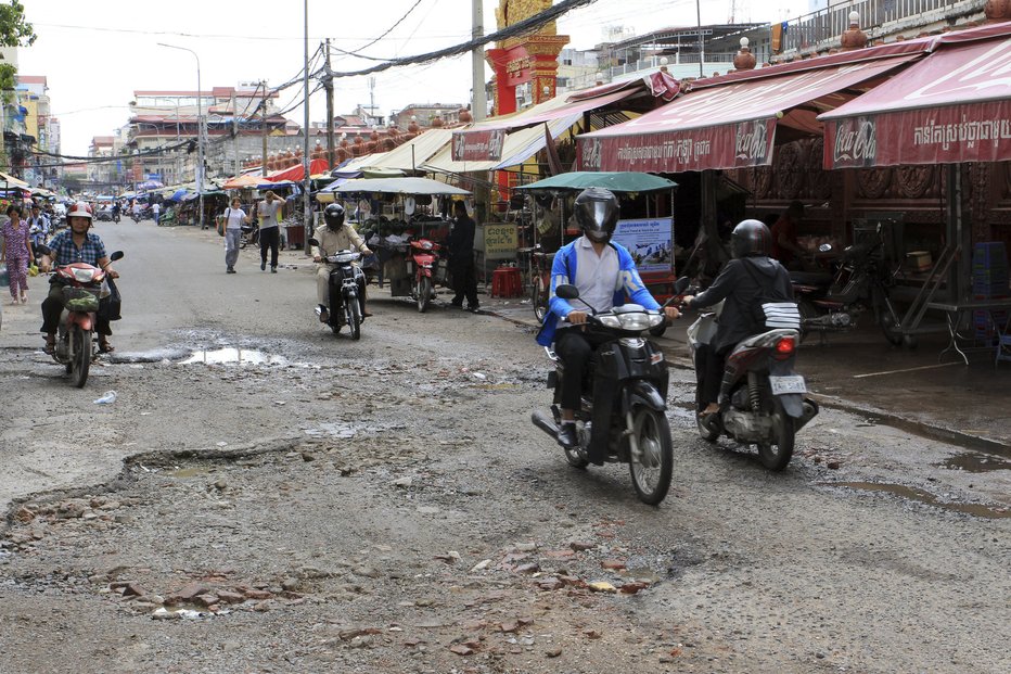 Hlavní ulice v Phnom Penh. Skútr či motorka jsou oblíbenými dopravními prostředky, stejně tak rikša, neboli “tuk-tuk”.