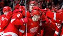 Patrick Kane je obklopen spoluhráči poté, co zaznamenal svůj 1375. bod, čímž překonal Mikea Modana a jeho rekord NHL v počtu bodů hráče narozeného v USA