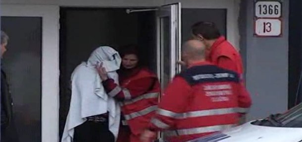 Záchranáři vyvádějí dívku z budovy školy.