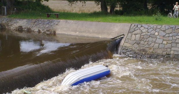 Převrácená nafukovací kánoe pod jezem