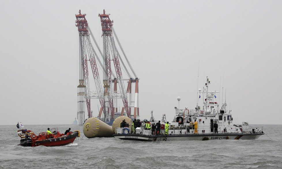 Jihokorejští námořníci prohledávají oblast, kde se trajekt potopil.