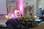Pódium kostela zdobí smuteční věnce, květiny a fotka Jana Kaplického