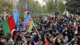 Ázerbájdžánci oslavují  národními vlajkami a drží portrét ázerbájdžánského prezidenta Ilhama Alijeva v úterý 10. listopadu 2020 v ázerbájdžánském Baku.