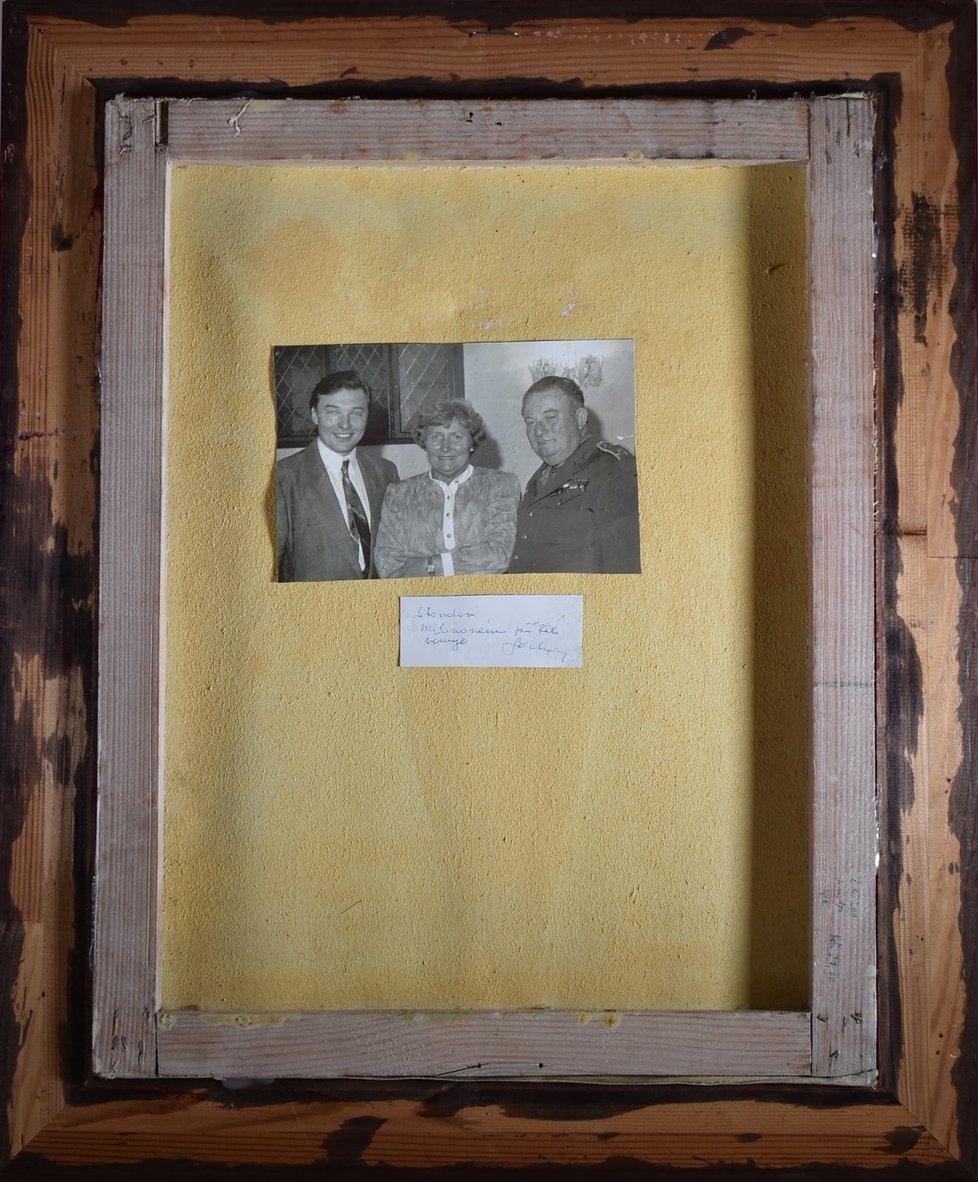 Na zadní straně obrazu je fotografie Karla Gotta, Věry Štrougalové a plukovníka Miloslava Soukupa