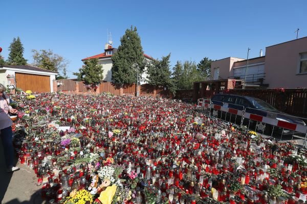 Svíčky, květiny a další předměty zaplavily celou ulici. Mezi nimi bylo uvězněné auto, které majitel nestihl přeparkovat