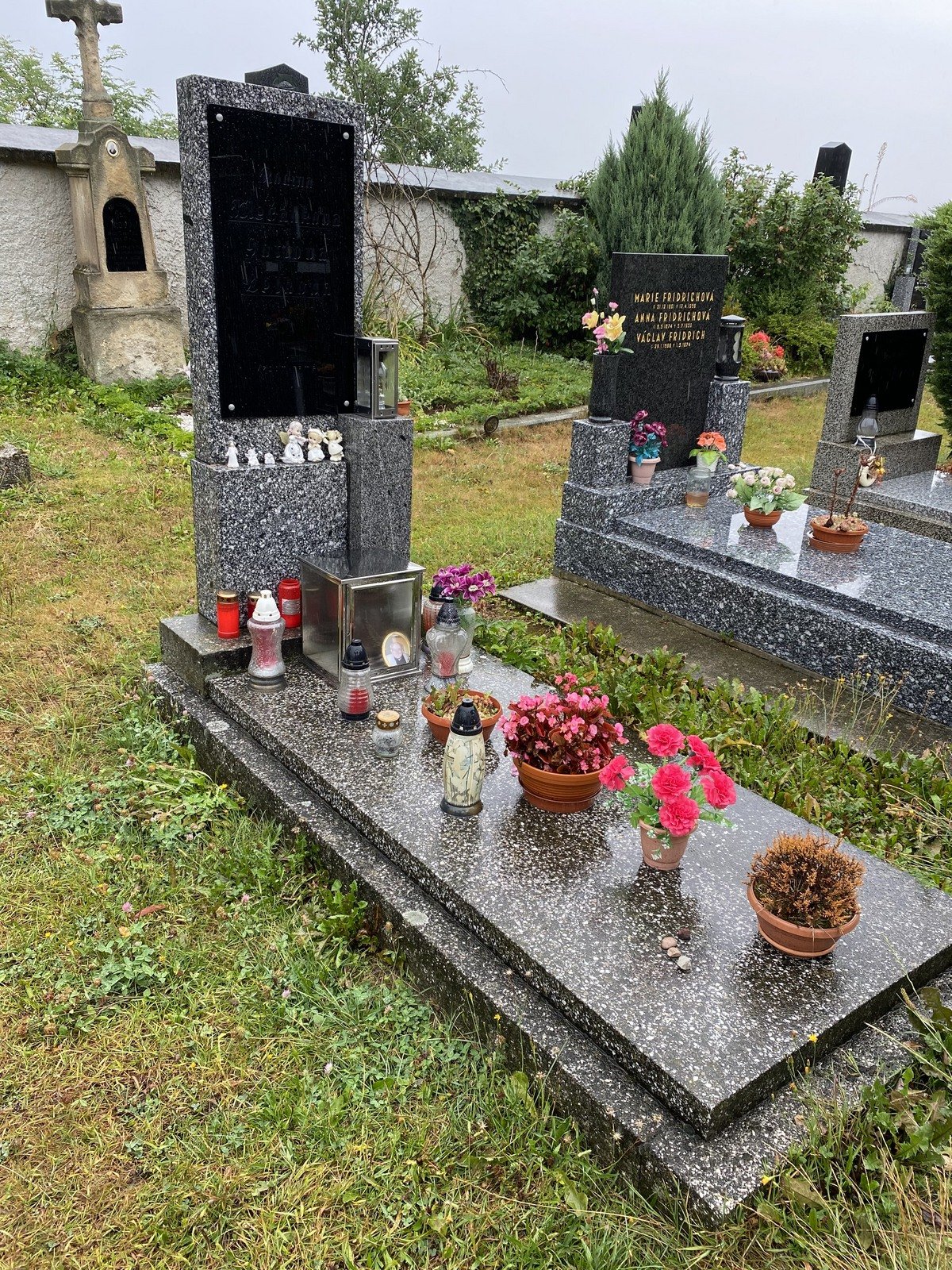 Hrob Gottových rodičů je plný květin, náhrobní deska ale smytím jmen úplně zčernala.