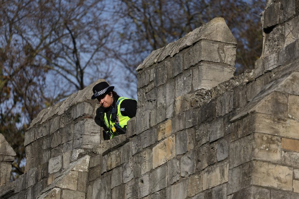 Policistka kontroluje situaci z hradeb.