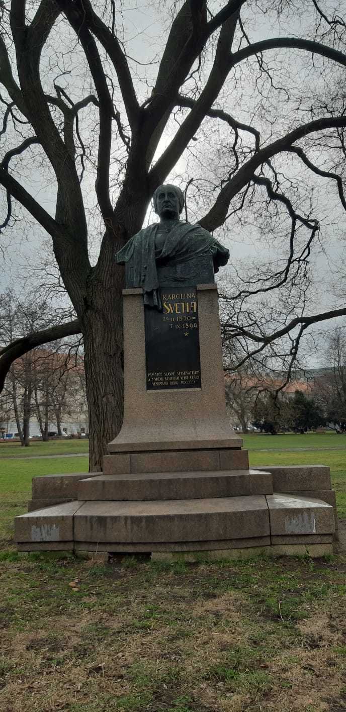 Pomník Karoliny Světlé na Karlově náměstí. V jednom z domů, které lemují jeho obvod, věhlasná spisovatelka dožila.