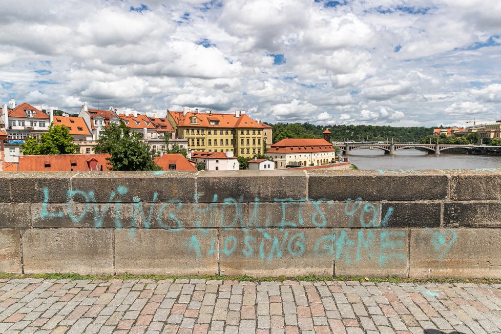 Neznámý vandal 9. července 2021 posprejoval část Karlova mostu v Praze. Modré nápisy v angličtině jsou na zídce na pravé straně mostu směrem k Pražskému hradu.